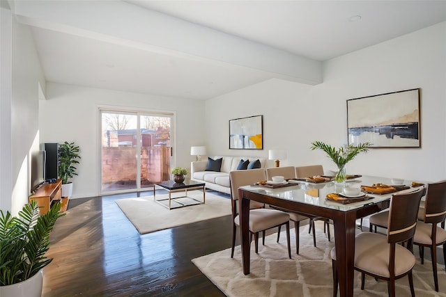 dining room featuring beamed ceiling and dark wood-type flooring