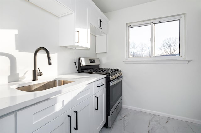 kitchen with white cabinetry, sink, and stainless steel gas range