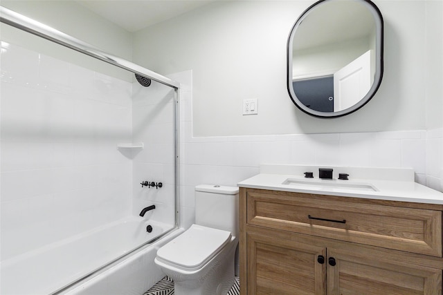 full bathroom featuring toilet, vanity, tile walls, and combined bath / shower with glass door