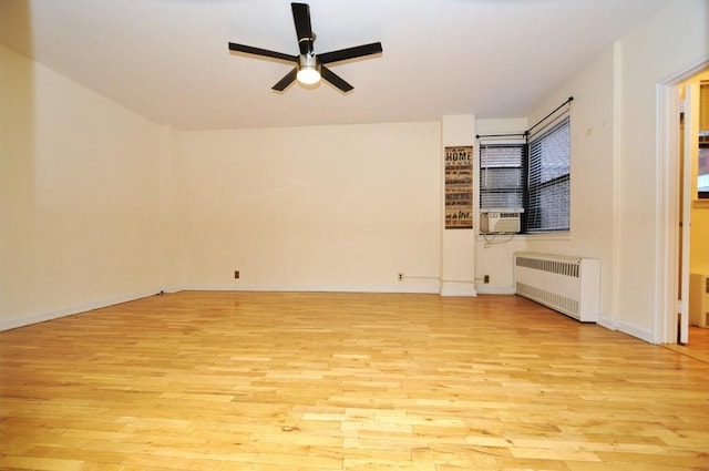 unfurnished living room with ceiling fan, cooling unit, radiator, and light hardwood / wood-style flooring