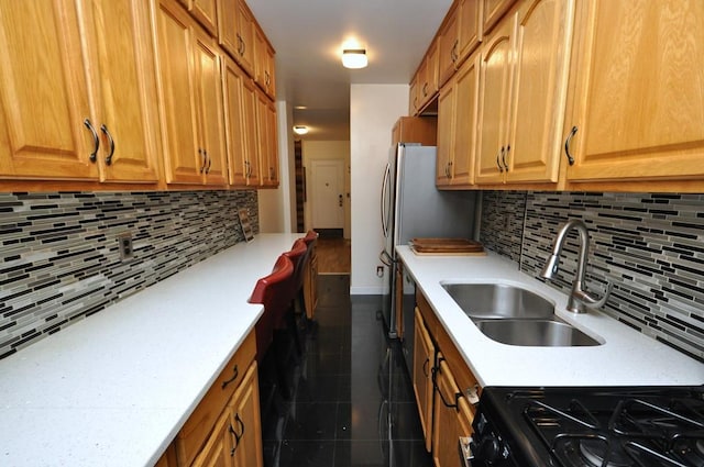 kitchen featuring tasteful backsplash, sink, and gas stove