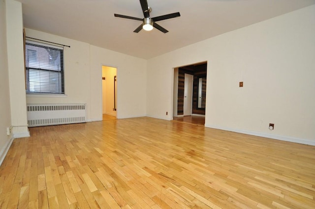 unfurnished living room featuring ceiling fan, radiator, and light hardwood / wood-style flooring