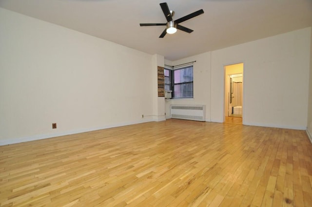 unfurnished room featuring ceiling fan, radiator heating unit, and light wood-type flooring