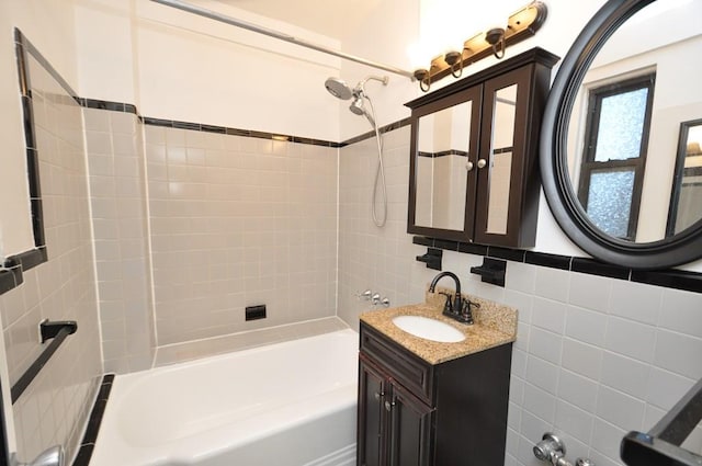 bathroom featuring vanity, decorative backsplash, tile walls, and tiled shower / bath