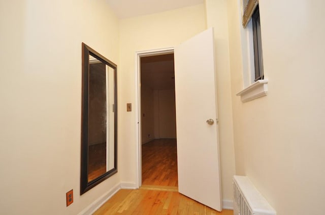 hall featuring radiator and light hardwood / wood-style flooring