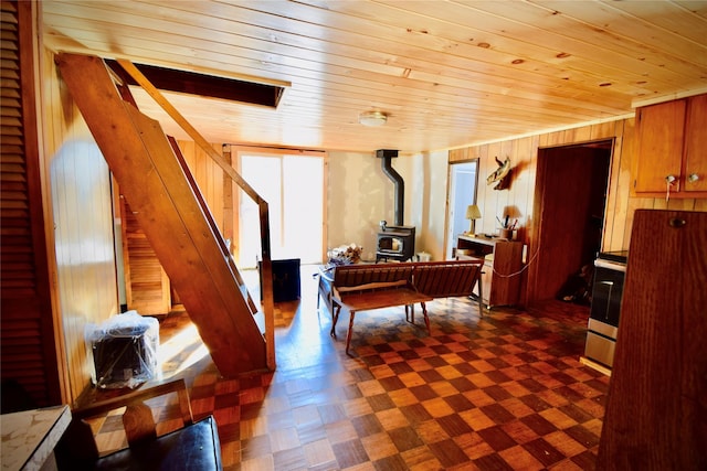339 Mountain Lake Rd, Andes, NY 13731 - sitting room featuring a wood stove, wood ceiling, wood walls, stairs, and dark floors