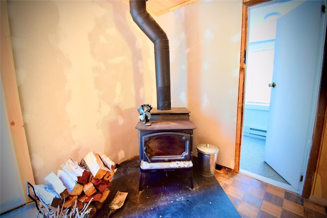 interior details featuring a wood stove and a baseboard heating unit