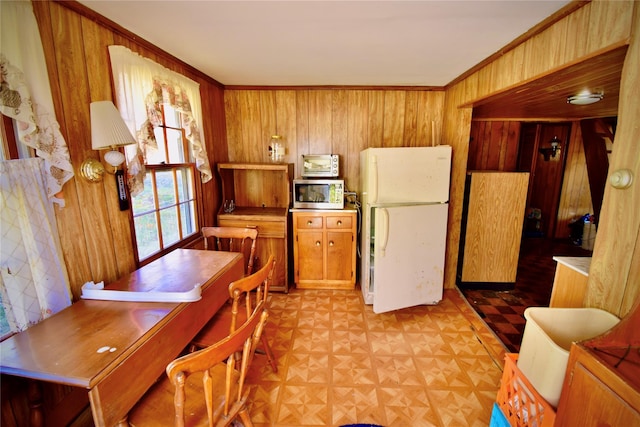 kitchen featuring wood walls, white refrigerator, and light parquet floors