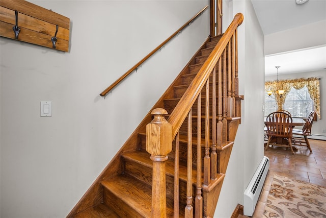 stairway with baseboard heating, tile patterned floors, and a chandelier