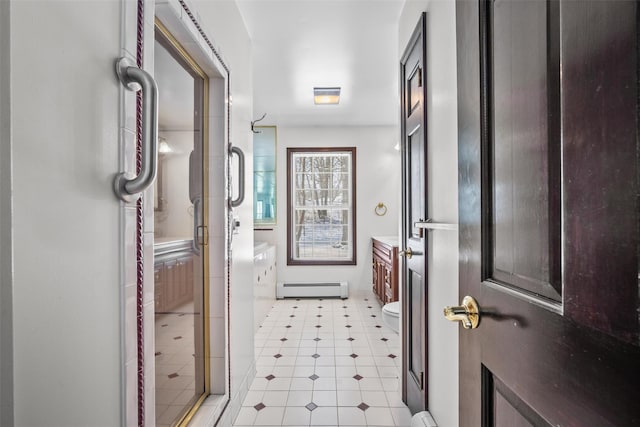 full bath featuring toilet, vanity, baseboard heating, and a stall shower