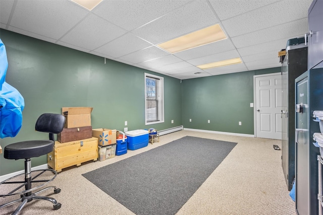 interior space featuring carpet flooring, baseboards, a drop ceiling, and a baseboard radiator