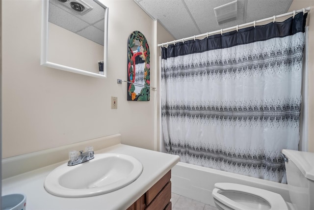 full bath featuring vanity, tile patterned flooring, toilet, shower / bathtub combination with curtain, and a drop ceiling