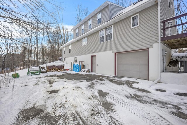 snow covered property with a garage