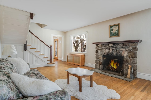 living room with a fireplace, light wood-type flooring, and radiator