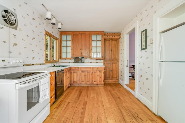 kitchen featuring white appliances, light hardwood / wood-style floors, and sink