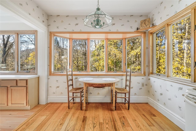 sunroom featuring a chandelier and a healthy amount of sunlight