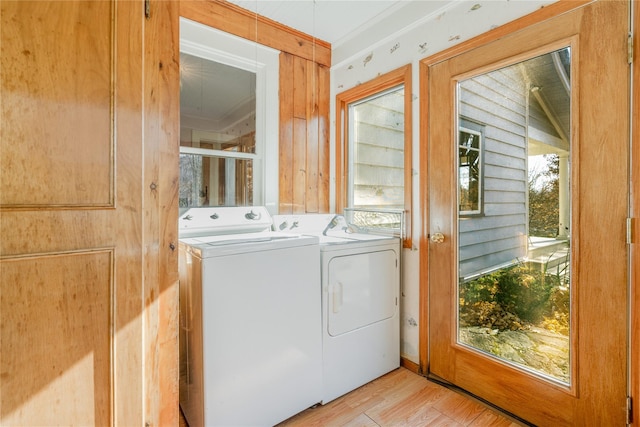 washroom featuring light wood-type flooring, crown molding, and separate washer and dryer