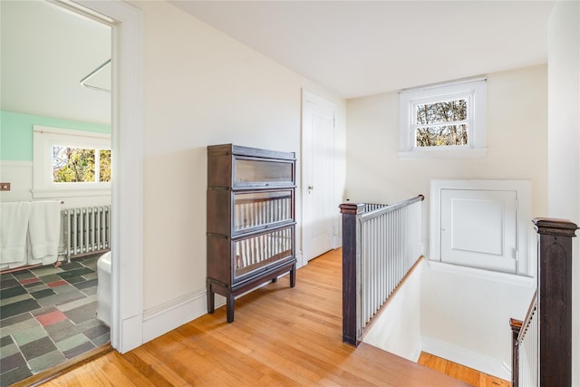 hall featuring wood-type flooring and radiator