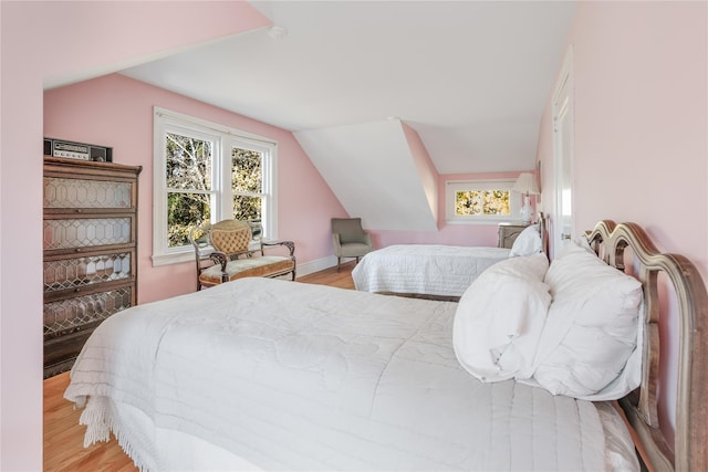 bedroom featuring light wood-type flooring and vaulted ceiling