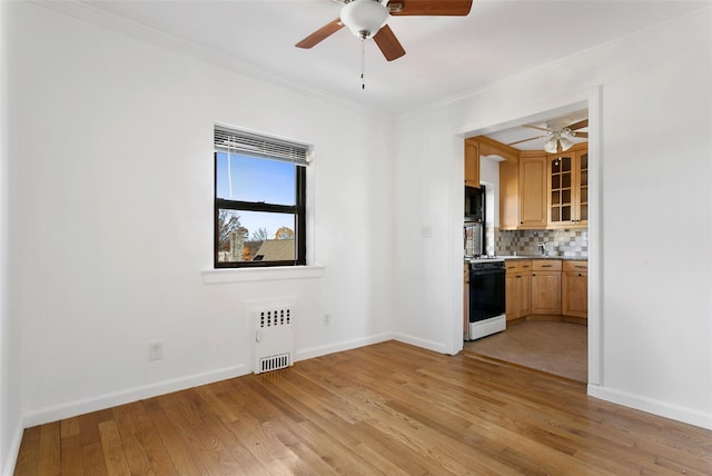 interior space with radiator heating unit, light wood-type flooring, and crown molding