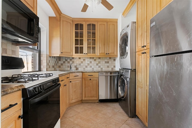 kitchen featuring backsplash, black appliances, light stone countertops, light tile patterned floors, and stacked washer / drying machine