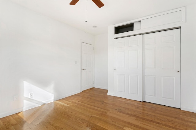 unfurnished bedroom featuring hardwood / wood-style floors, a closet, and ceiling fan