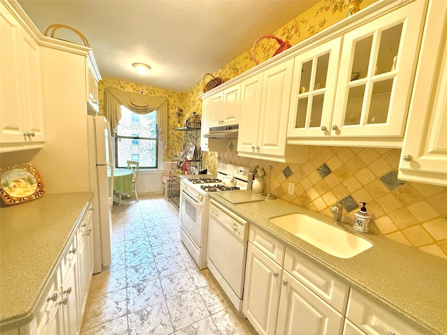 kitchen with backsplash, sink, and white appliances