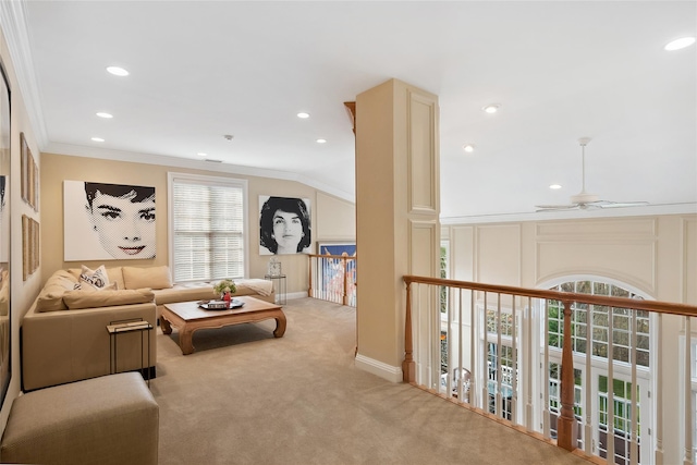 carpeted living room with ceiling fan and crown molding