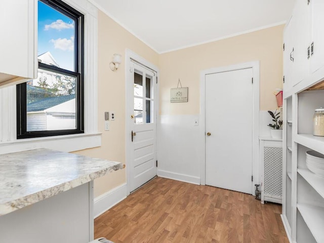 entryway featuring light hardwood / wood-style floors and crown molding