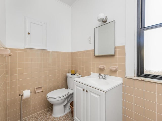 bathroom featuring vanity, ornamental molding, tile walls, and toilet