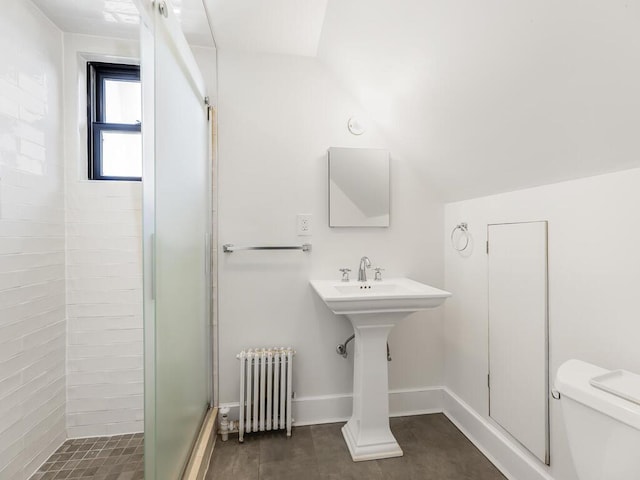 bathroom featuring toilet, vaulted ceiling, radiator, and walk in shower