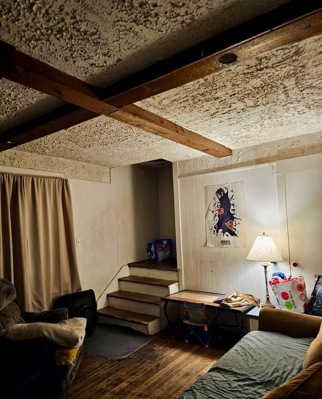 interior space with beam ceiling, wood walls, and hardwood / wood-style flooring