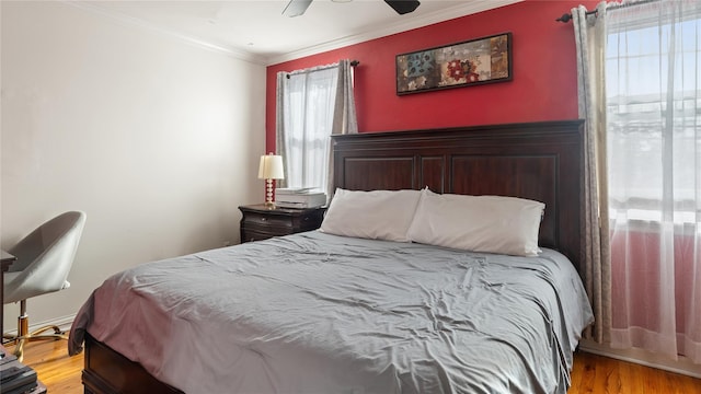 bedroom with light wood-type flooring, multiple windows, crown molding, and ceiling fan