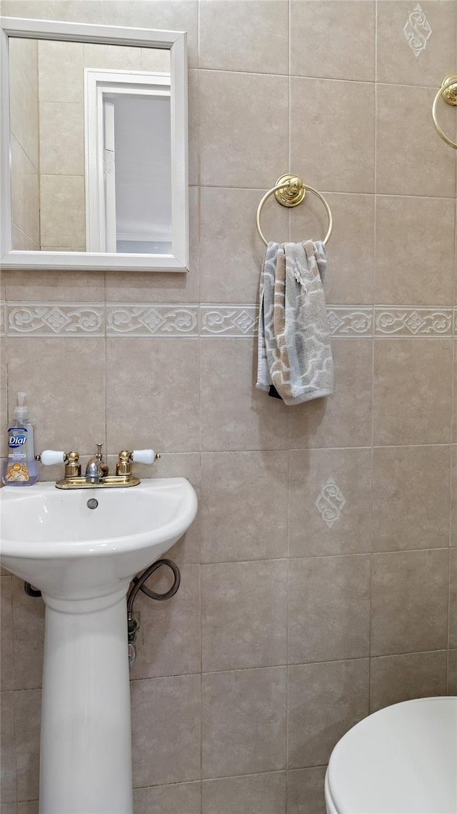 bathroom with decorative backsplash, tile walls, and toilet