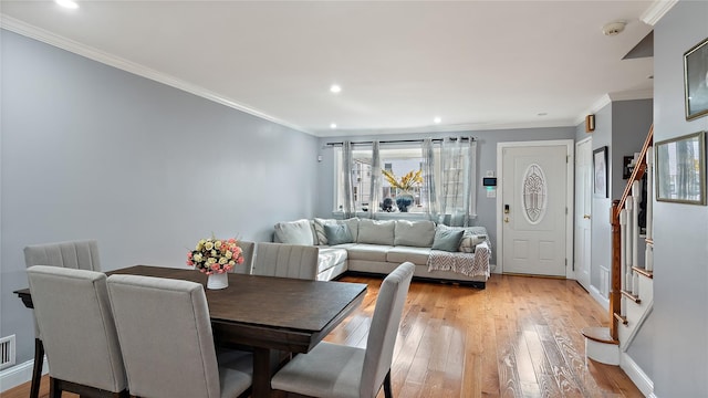 dining area with crown molding and light hardwood / wood-style floors