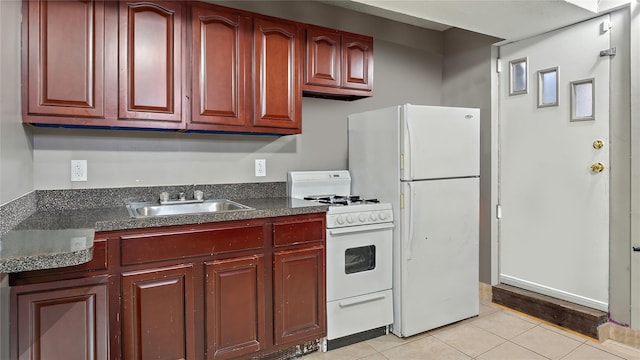 kitchen featuring light tile patterned flooring, white appliances, and sink