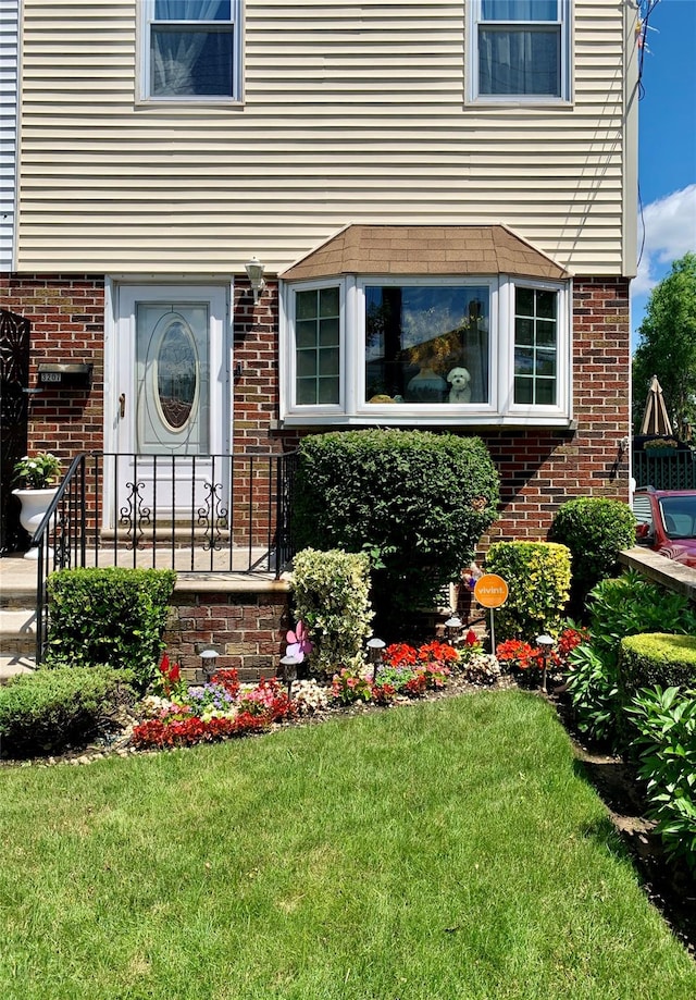 property entrance with a lawn