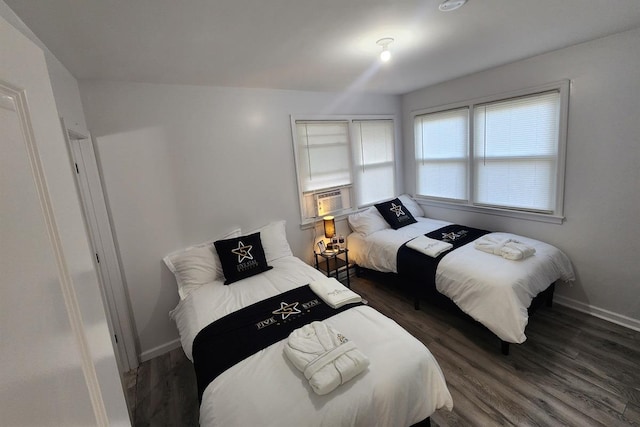 bedroom with cooling unit and dark hardwood / wood-style flooring