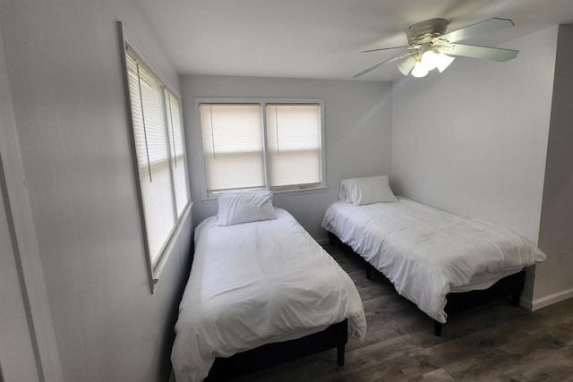 bedroom with multiple windows, ceiling fan, and dark hardwood / wood-style floors