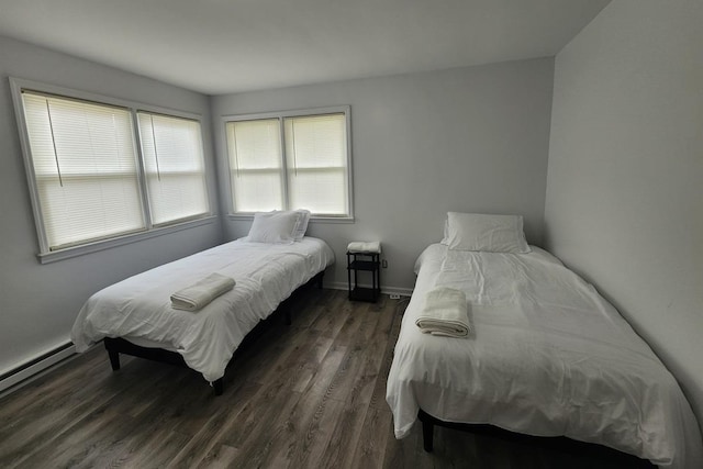 bedroom with baseboard heating and dark wood-type flooring