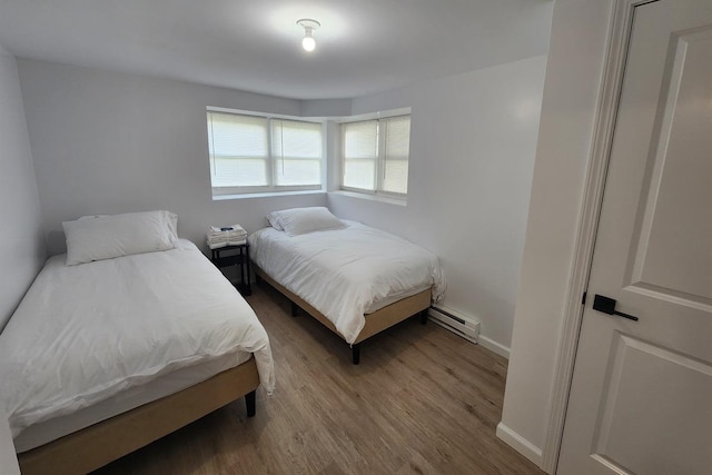 bedroom featuring light hardwood / wood-style flooring and a baseboard heating unit