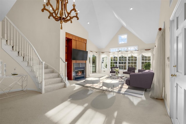 carpeted living room featuring an inviting chandelier, high vaulted ceiling, and a tiled fireplace