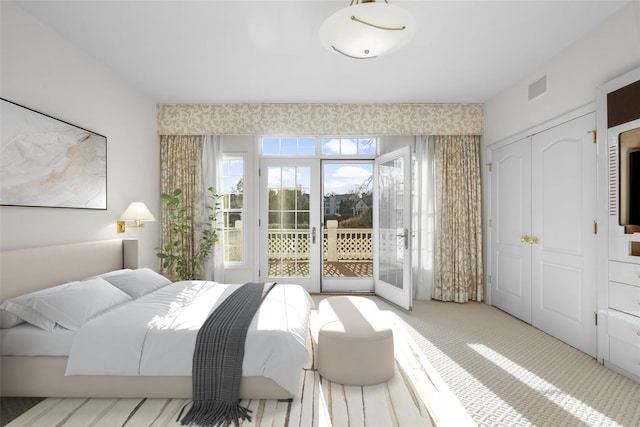 bedroom featuring access to outside, a closet, and light colored carpet