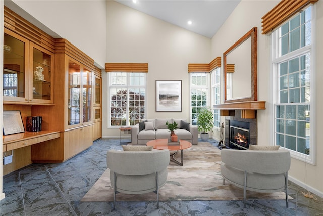 sitting room featuring a fireplace and high vaulted ceiling