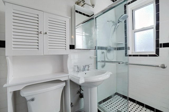 bathroom featuring backsplash, toilet, tile walls, and walk in shower