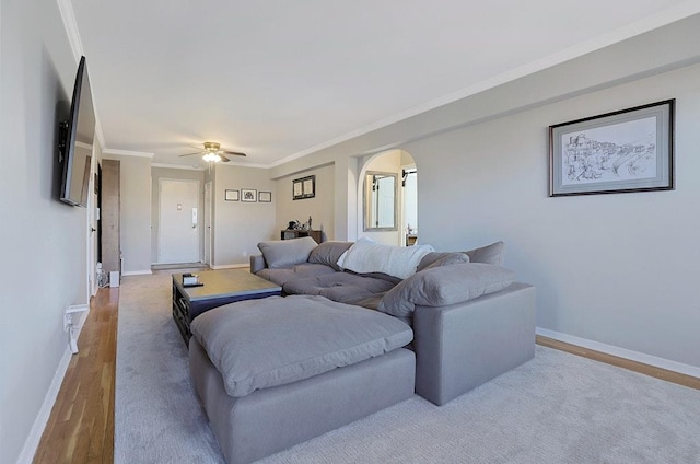 living room with ceiling fan, light hardwood / wood-style floors, and crown molding