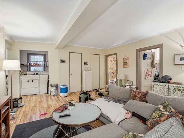 living room with beamed ceiling, independent washer and dryer, crown molding, and light hardwood / wood-style flooring