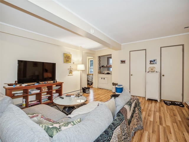 living room featuring beamed ceiling, light wood-type flooring, crown molding, and a baseboard heating unit