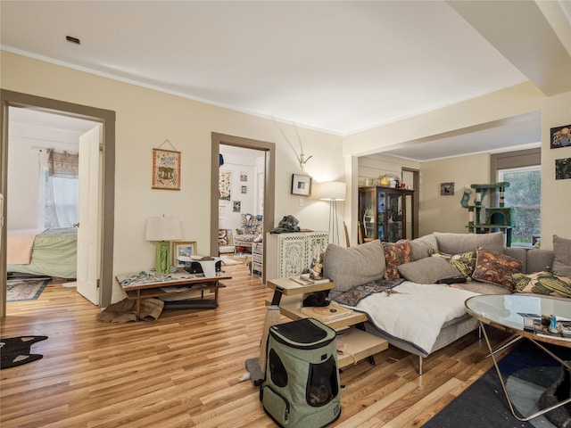 living room with light hardwood / wood-style floors and crown molding