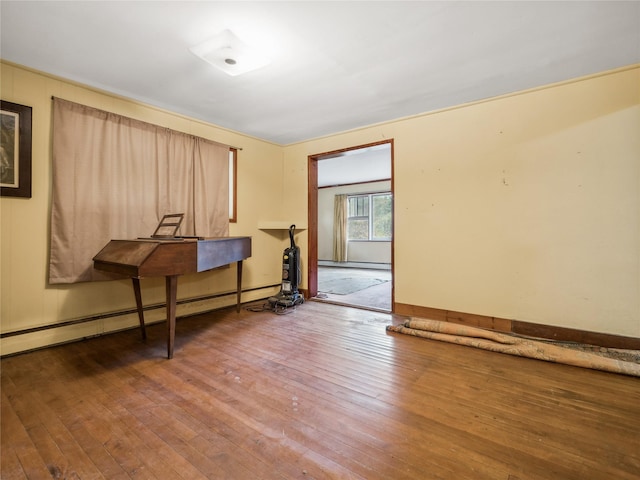 miscellaneous room with wood-type flooring and a baseboard heating unit